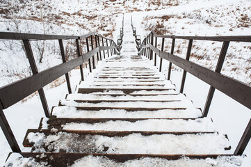 Obraz premium wooden staircase leading down in winter