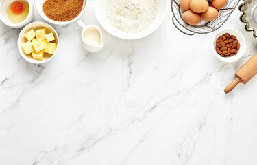 Baking background with ingredients standing on a marble table surface