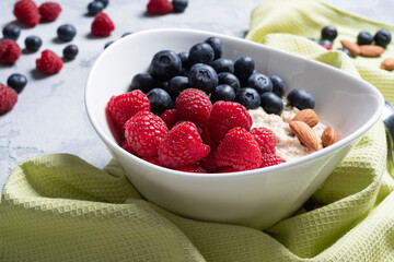 oatmeal in a plate with raspberries and blueberries and almonds close-up