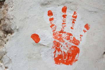 Red hand print on white wall