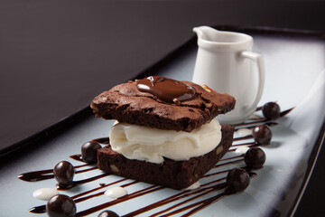 Brownie cake with ice cream and chocolate sauce close up