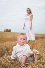 Beautiful mother and son are photographed in a wheat field