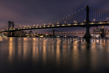 Obraz premium View of Manhattan bridge and Brooklyn Bridge from east river with long exposure at dawn