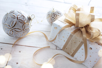 Christmas gift with golden ribbon bow
Gift with golden ribbon bow and christmas baubles on white...