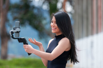 influential latino woman doing a live broadcast with a gimbal
