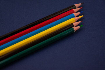 Bright multi-colored pencils on a blue background.