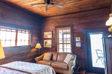 A rustic cozy living room in a fishing and hunting cabin with wood-paneled walls and ceiling