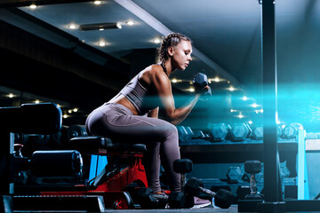 Fototapeta na wymiar beautiful young black sportswoman in the gym. performs a workout.
