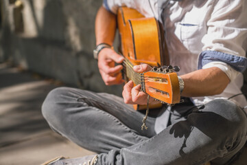 Close up male street musician playing guitar. Selective focus.