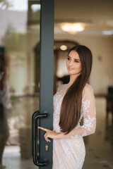 Beautiful young model in evening drees posing to photographer inside big restaurant