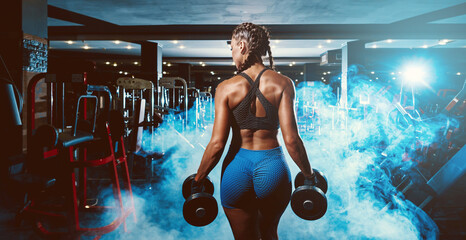 Obraz na płótnie Canvas beautiful young black sportswoman in the gym. performs a workout.