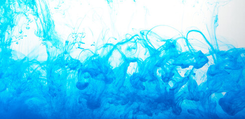 Fototapeta na wymiar Closeup of a blue ink in water in motion isolated on white. Ink swirling underwater. Colored abstract smoke explosion effect. Abstract background with copy space..