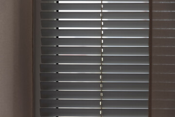 Horizontal white blinds block out the sunlight.