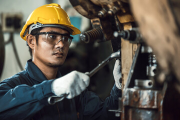 mechanic man checking and repair metal work pressing machine at factory.