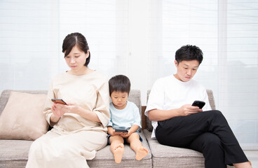 Obraz premium スマホを見る3人家族