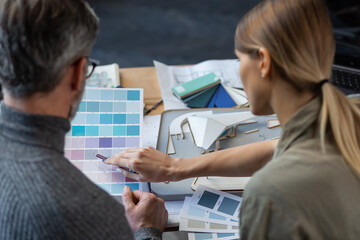 Interior designers team working in office with color palette. Architects select colors for building using color swatches, sketching and planning construction project. Partners discussing at work.