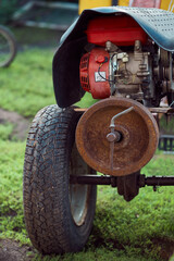 Fototapeta premium Walk-behind tractor on lawn in yard in countryside