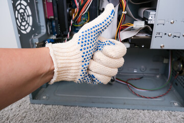 A repairer technician showing thumb up against disassembled computer system block