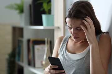 Sad teen checking smart phone at home in the night