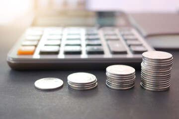 Stack coin for growing business and calculator on the table. Concept of finance and business.