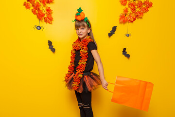 Child in Halloween costume carrying a shopping bag