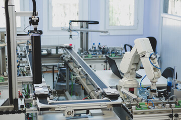 Industry 4.0 concept; artificial intelligence in smart factory prototype. The robot picks up the product from an automated car on the production line. Focus on the robotic arm's gripper.