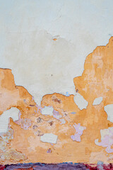 damaged weathered multicolored coating of paint of concrete building wall with many patches