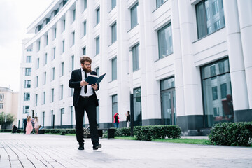 Focused businessman reading documents outside