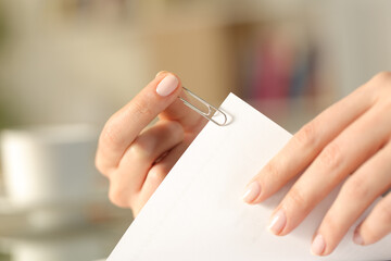 Close up of a woman hands putting a paper clip on a sheet