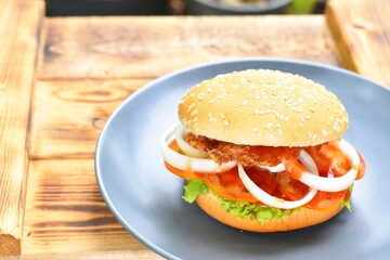 The burgers are in a gray ceramic plate on a wooden table.