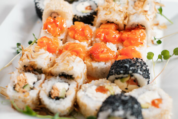 Japanese sushi food. Maki and rolls. Decorated with greenery.