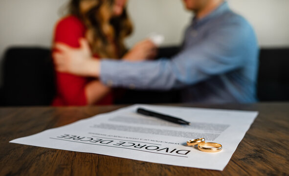 Divorce decree document. Man calms down a woman on the background.