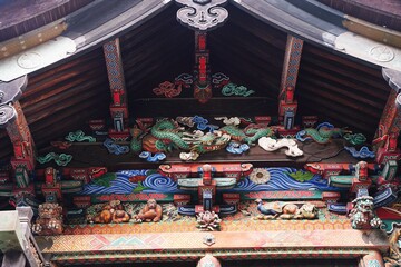 Colorful shrine wood carving decoration at Chichibu Jinja Shrine in Chichibu, Saitama, Japan. Dragon, Kiji bird and three monkeys.