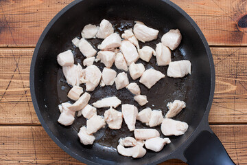 Step by step cooking fried potatoes with chicken fillet and onions, step 2 - frying the chopped chicken fillet, top view