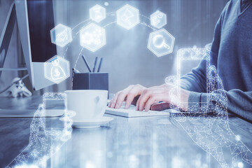 Technology theme hologram with man working on computer on background. High tech concept. Double exposure.