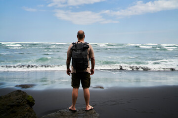 Unrecognizable man admiring waving sea