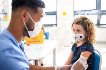 Child with face mask getting vaccinated, coronavirus, covid-19 and vaccination concept.