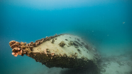 Ship wreck in turquoise water of coral reef in Caribbean sea / Curacao
