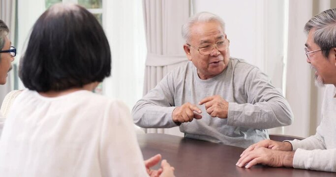 Senior man talking funny story to his friend at home. They laughing about funny story together. Senior people having meeting together at home. Retirement activity or lifestyle concept.