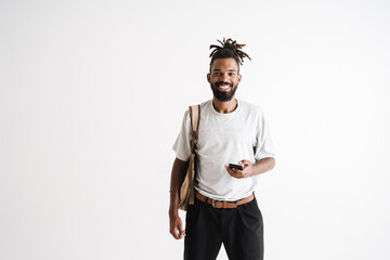 Photo of joyful african american guy smiling and using mobile phone
