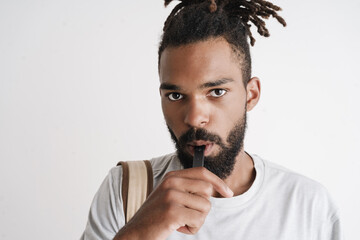 Photo of unshaven african american guy smoking electronic cigarette