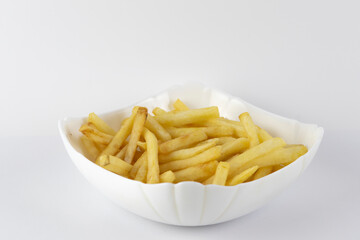 Fried potatoes in a white cup on a white plate.