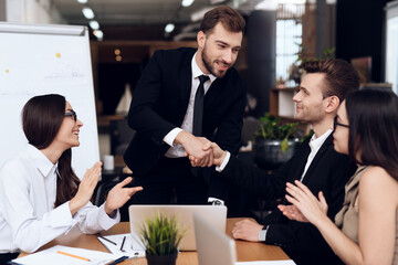 Man in suits shake hands for excellent work.