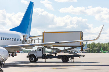 Loading food and other service items for a passenger plane flight.