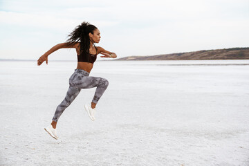 Image of african american sportswoman running while working out