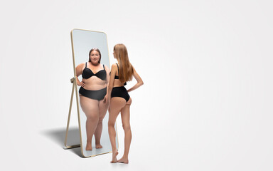 Young fit, slim woman looking at fat girl in mirror's reflection on white background. Thinking...