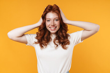 Image of ginger joyful girl smiling and grabbing her head