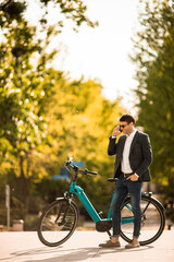 Young businessman on the ebike using mobile phone