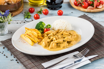 Chicken Curry Sauce. Served with rice. Natural wooden background.