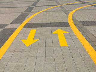 Up and down arrows on the road. Yellow arrows on the road, directing traffic flow
